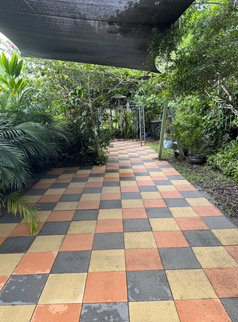 Clean colourful checkerboard paving in a leafy garden