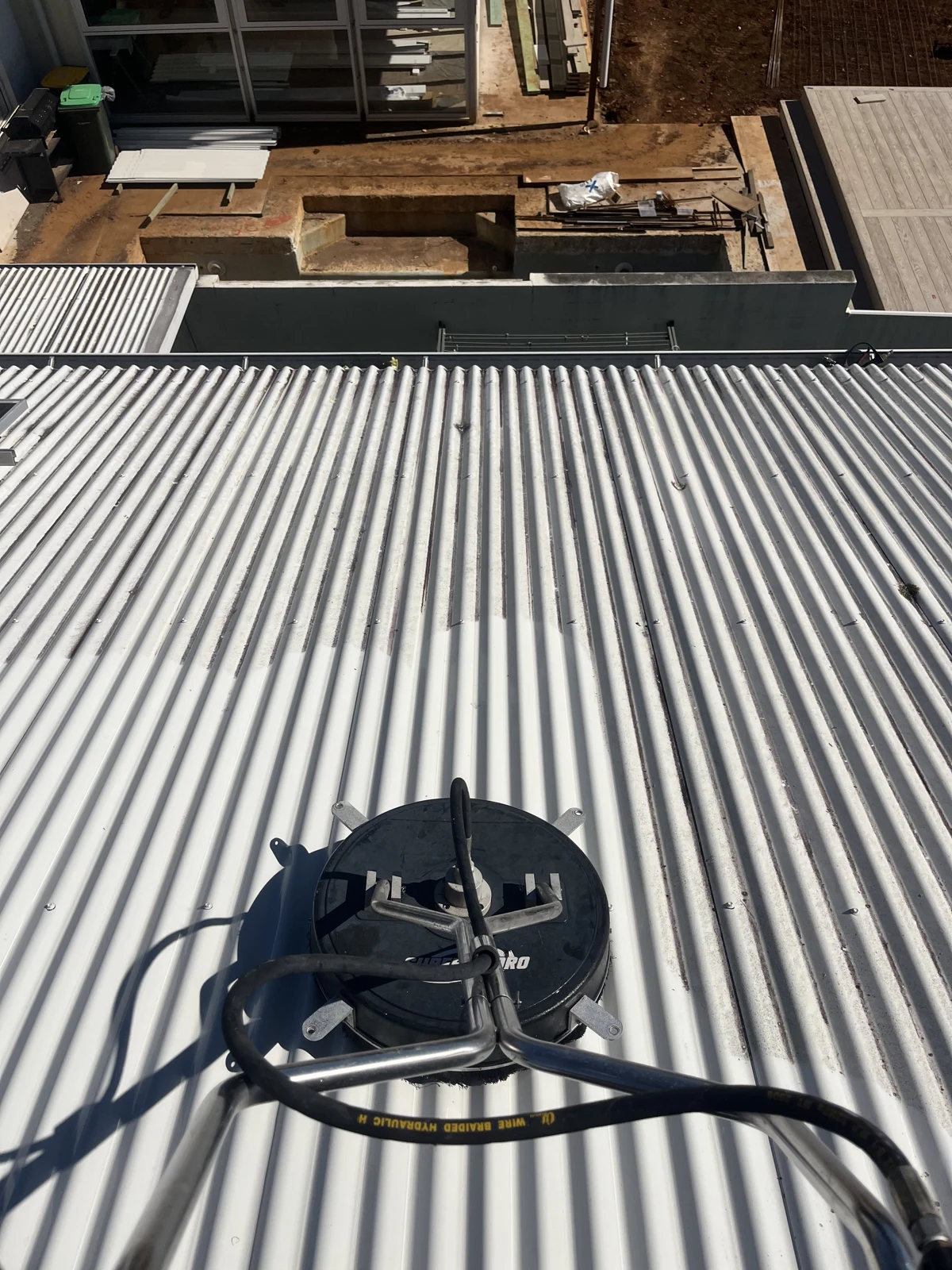 Surface cleaner at work on a metal roof